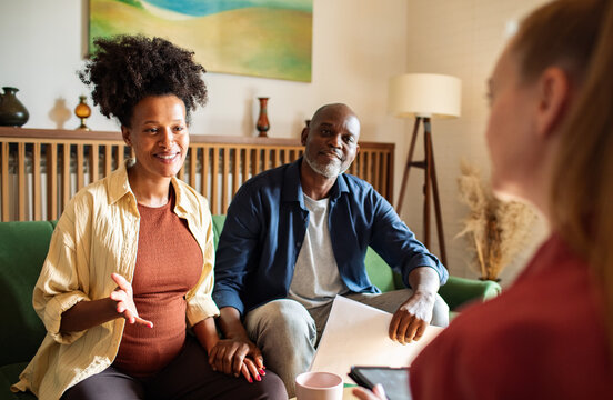 Expecting couple holding hands during home consultation