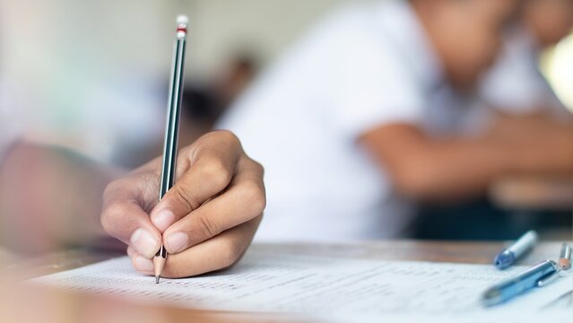 Close-up of Student Hand Holding Pencil Filling Answer Sheet in Final Exam