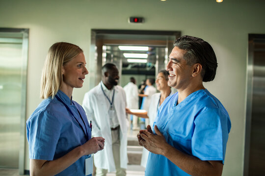 Doctors and nurses talking in hospital elevator lobby