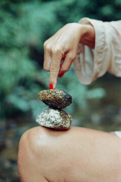 Woman balancing rocks on her knee