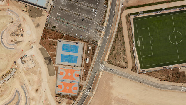 Aerial view of sports fields and urban development.