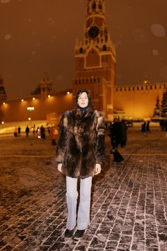 Model Stands in Front of the Kremlin at Night in Winter