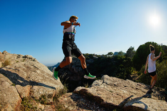 People jumping across rocks during outdoor activity