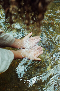 Woman cupping fresh water in their hands
