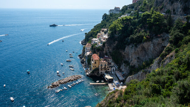 CONCA DEI MARINI, ITALY: Scenic panoramic view of Conca dei Marini village, colorful houses on cliffs and sea with boats on Amalfi Coast.