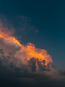 Dramatic orange storm cloud beneath dark evening sky