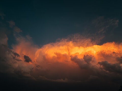 Dramatic orange storm cloud glowing beneath dark sky