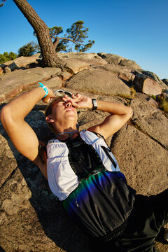 Runner resting on rock during outdoor activity in bright sun