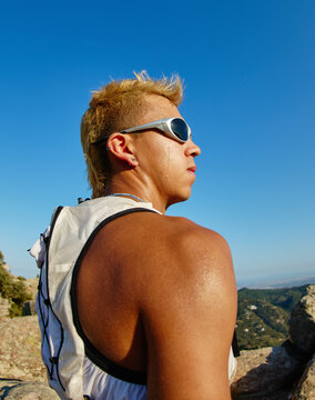 Runner taking a break on a mountain trail during a sunny day