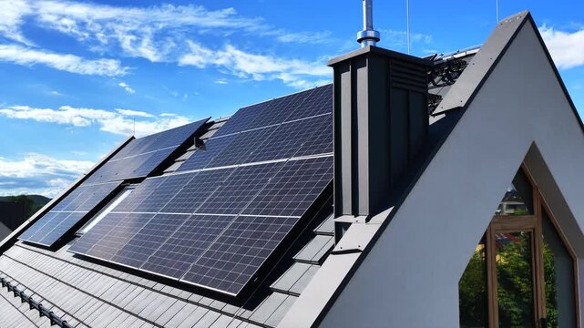 Solar panels beside a chimney on a modern pitched roof