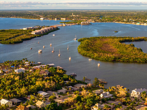 Vacation paradise on Manasota Key in Englewood, Florida at colorful sunset. Popular Gulf Coast getaway with beachfront homes and palms.