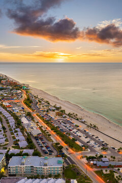Vacation paradise on Manasota Key in Englewood, Florida at colorful sunset. Popular Gulf Coast getaway with beachfront homes and palms.