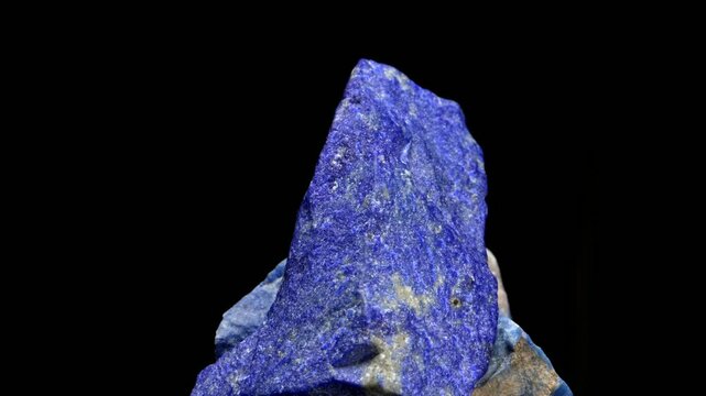 Lapis Lazuli - metamorphic semi-precious rock containing lazurite, pyrite and calcite - rotating slowly against a black background	