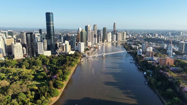 Aerial drone view of the Brisbane River, Kangaroo Point Green Bridge and the skyline with flowering jacaranda trees, Brisbane, Australia.