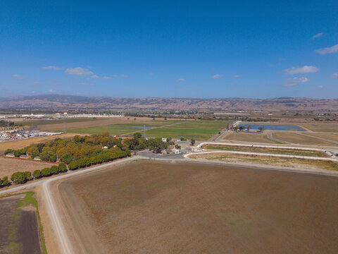 Water treatment facility and irrigation ponds managing resources for surrounding agricultural fields, reflecting water scarcity and sustainable farming practices in a rural landscape