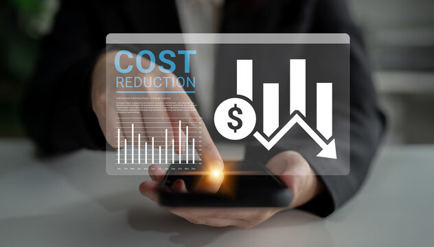 A business professional interacts with a smartphone displaying financial graphs, illustrating cost reduction strategies and data analysis in a corporate environment. Ledger