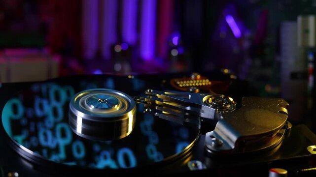 Futuristic server mainframe computing node under cyber attack. Cinematic camera dolly right movement with tracking parallax angle revealing binary matrix code on spinning hard drive plate under red