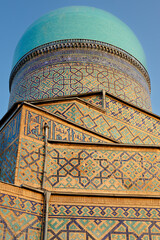 Turquoise dome and geometric tilework of Tilla Kari Madrasah at Registan Square in Samarkand. Detailed architectural close-up ideal for travel publications and cultural heritage materials. © finepoints