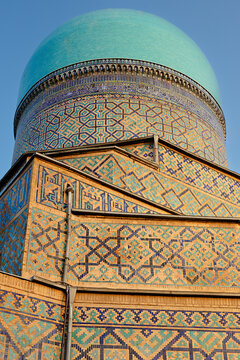 Turquoise dome and geometric tilework of Tilla Kari Madrasah at Registan Square in Samarkand. Detailed architectural close-up ideal for travel publications and cultural heritage materials.