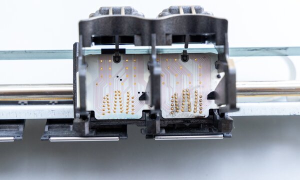 Underside of printer ink cartridges revealing circuit board and contact pins