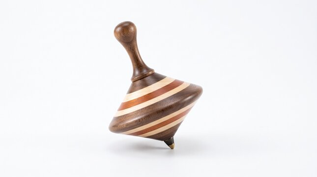 Spinning top wooden toy concept photo. Handmade wooden spinning top balancing on a metallic tip. Striped natural timber body with dark brown and light tan segments. Isolated on white background