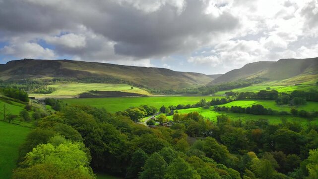Soft light breaks through clouds above rolling green hills