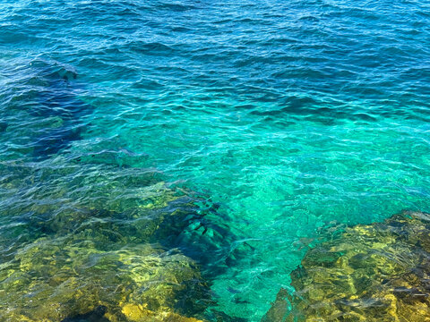 Transparent seawater with gradients shifting from turquoise near the shore to a deep blue hue