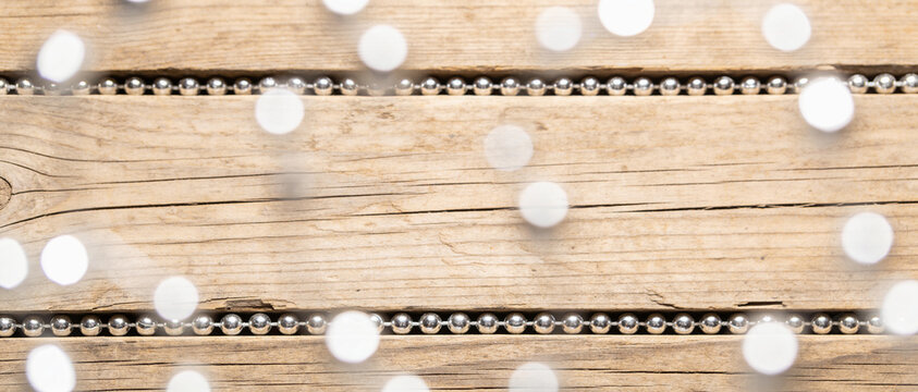 Festive string lights hanging on a rustic wooden background with white copy space