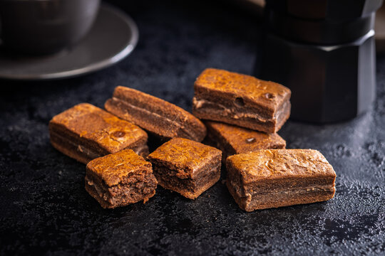 Close-Up Stack Of Chewy Chocolate Brownies With Crumbly Texture On Dark Surface