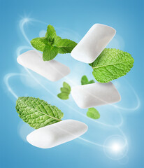 Menthol chewing gum pieces and mint leaves in air against blue background © New Africa