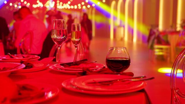 Grilled salmon fillet on banquet plate with wine glasses. Gourmet dinner at festive reception