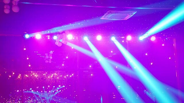 Stage spotlights and blue laser beams on ceiling. Green disco lighting at night party venue