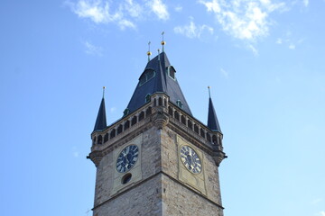 Historic clock tower top of old town hall with spires and clock faces against blue sky for architectural background and landmark study © iri.madrid.art