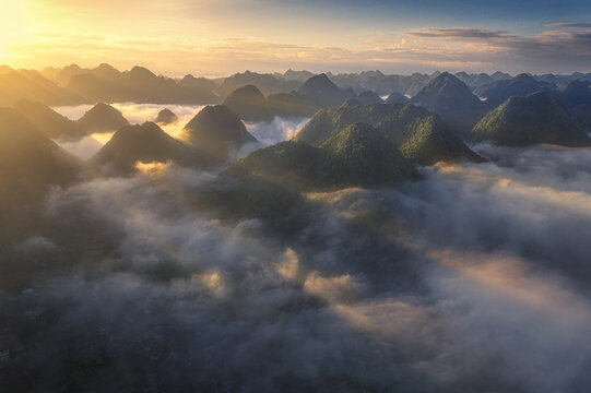 Aerial view of the Bac Son valley mountains emerging from a sea of clouds during a golden sunrise in Bac Son, Lang Son, Vietnam.