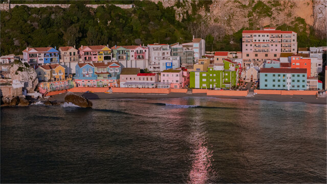 Aerial view of Catalan Bay with its colorful houses lining the beach, calm sea, and the dramatic rock face in the background, Gibraltar, Gibraltar.