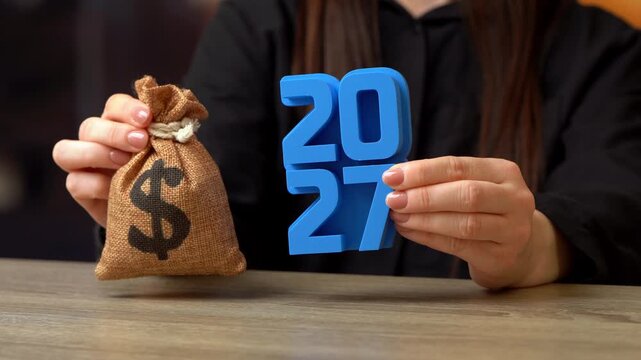 A dollar money bag and 2027 new year. Yearly budget, financial goals. Concept of financial planning, savings and smart investment strategy for the new year.
