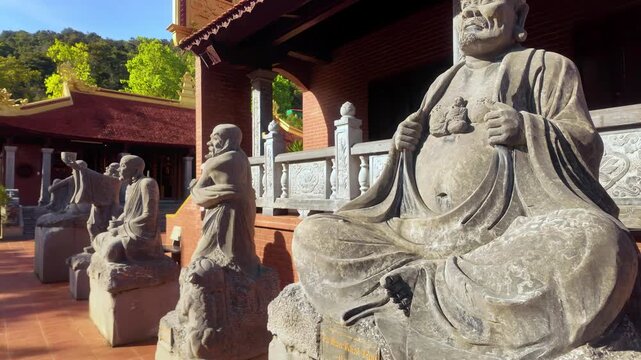 Guardians of Ho Quoc: A daytime ground-level shot of stone Arhat statues lining the courtyard of Ho Quoc Pagoda in Phu Quoc, Vietnam