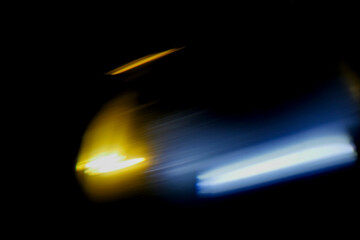 Abstract motion blur of car lights at night. Yellow and blue streaks glow against darkness. Perfect for themes like speed, nightlife, or urban travel. Suggests movement, mystery, and energy © mark_gusev