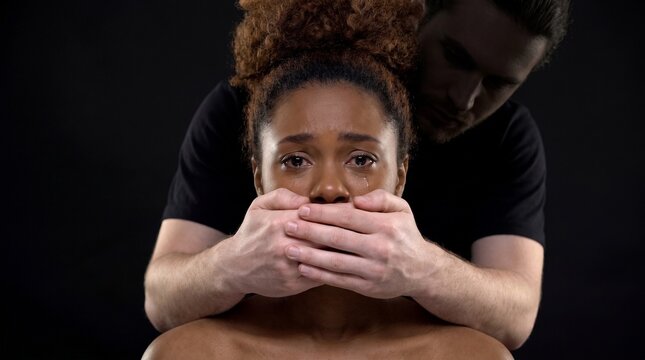 Man Silencing Crying Woman With Hands Against Dark Background Symbolizing Oppression and Fear