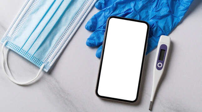 Medical flat lay with blue surgical mask, nitrile gloves, digital thermometer, smartphone on white marble surface. Healthcare equipment for virus prevention, pandemic protection, hygiene control.