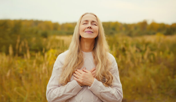 Calm relaxed young woman meditates, girl practicing doing yoga exercises outdoors, stress relief