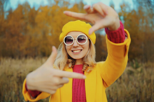 happy young woman smiling making frame sign with hands