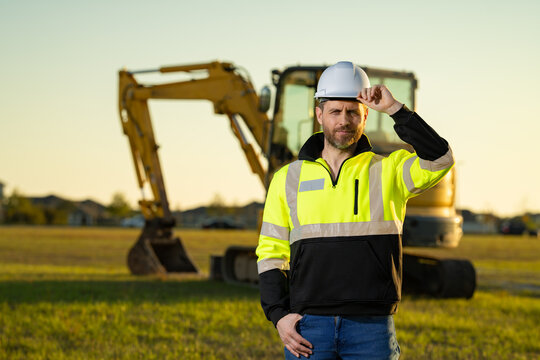 Portrait of builder in a construction site. Builder with excavator ready to build new house. Construction builder wear building uniform on excavation truck digging, builder construction.