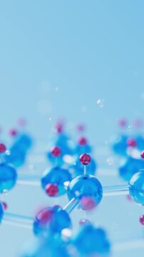 Closeup of a 3D blue and red metallic molecular lattice. Moving atoms linked by bonds with shallow depth of field. Scientific, cosmetics or healthcare concept loop animation. Vertical Video.