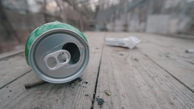Empty Crushed Beer Can and Cigarette Pack Littering Wooden Picnic Table | Discarded Trash Polluting Outdoor Recreation Area | Ultra Wide Angle Close-Up Slow Motion | Environmental Pollution