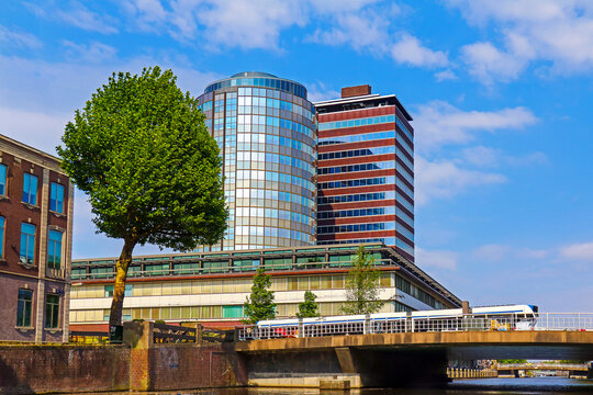 Netherlands bank building in Amsterdam with Hogesluis bridge over Amstel river in back