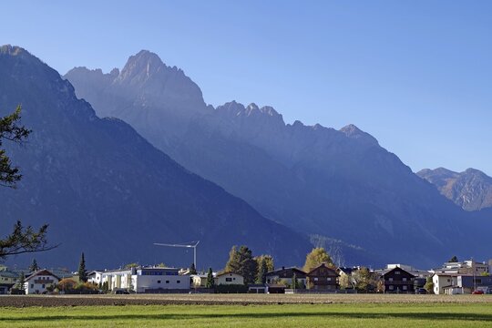 Village at the foot of rugged mountains, wide meadow in the foreground, clear air and soft light, Lienz Dolomites, Drau cycle path, Tyrol, Austria
