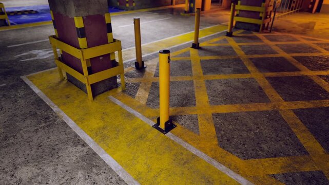 A parking area features striking yellow lines and safety poles. The floor showcases a blend of textures under dim lighting. The design emphasizes order and caution in a bustling environment.