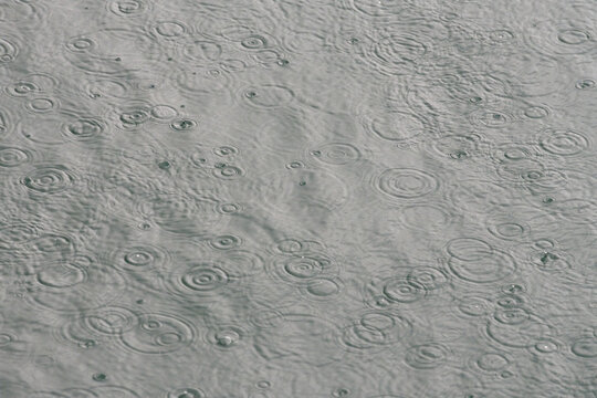 Grey water surface covered with rain ripples, natural background, Lake Lucerne, Switzerland