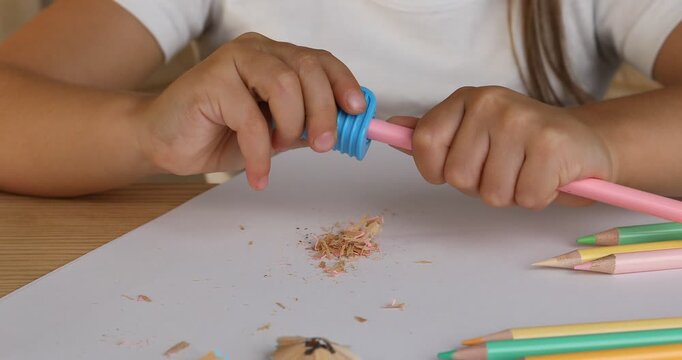 Child using simple prism sharpener at table, closeup